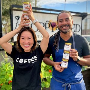 Founder Amy and Chef Michael Reed laughing and holding cans of bbq coffee rub