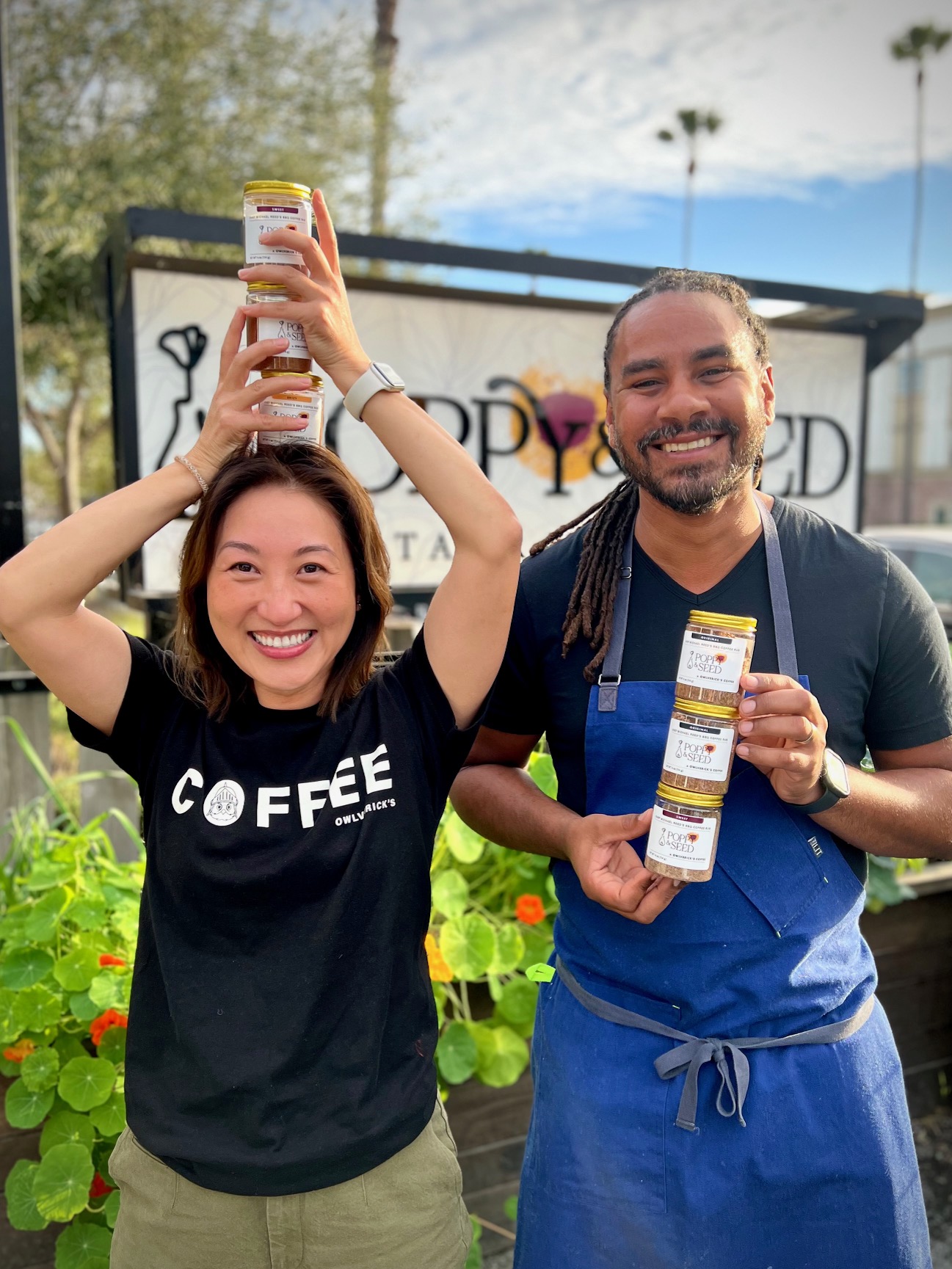 Founder Amy and Chef Michael Reed laughing and holding cans of bbq coffee rub